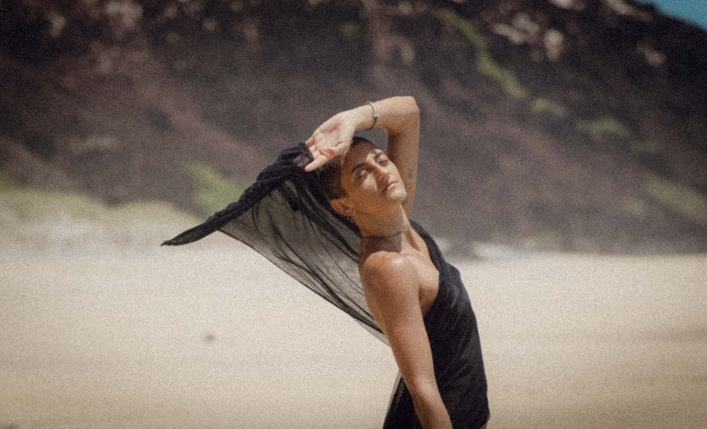 Véu preto ao vento, na areia